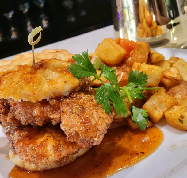 Hennessy and Honey Waffle Biscuit Sandwich, accompanied by seasoned potatoes